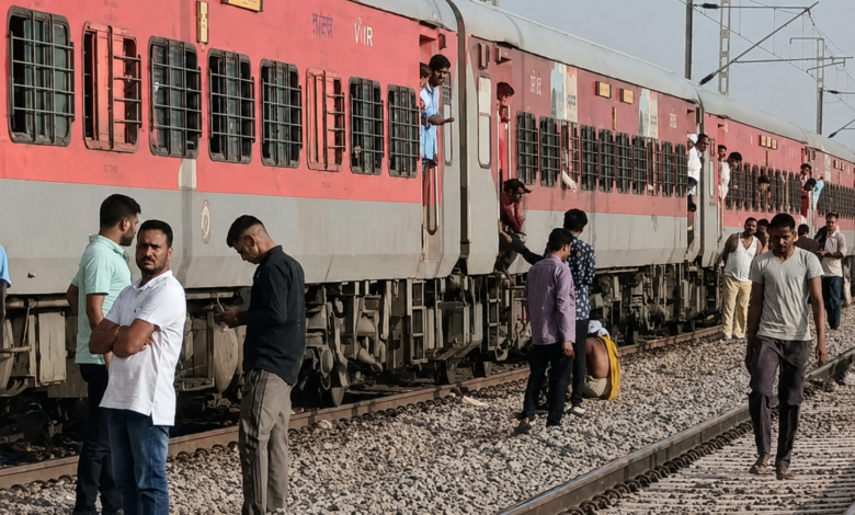 मुरैना रेल हादसे के दौरान रेलवे ट्रैक पर खड़ी ट्रेन के पास मौजूद यात्री, आग की अफवाह के बाद अफरा-तफरी का दृश्य।
